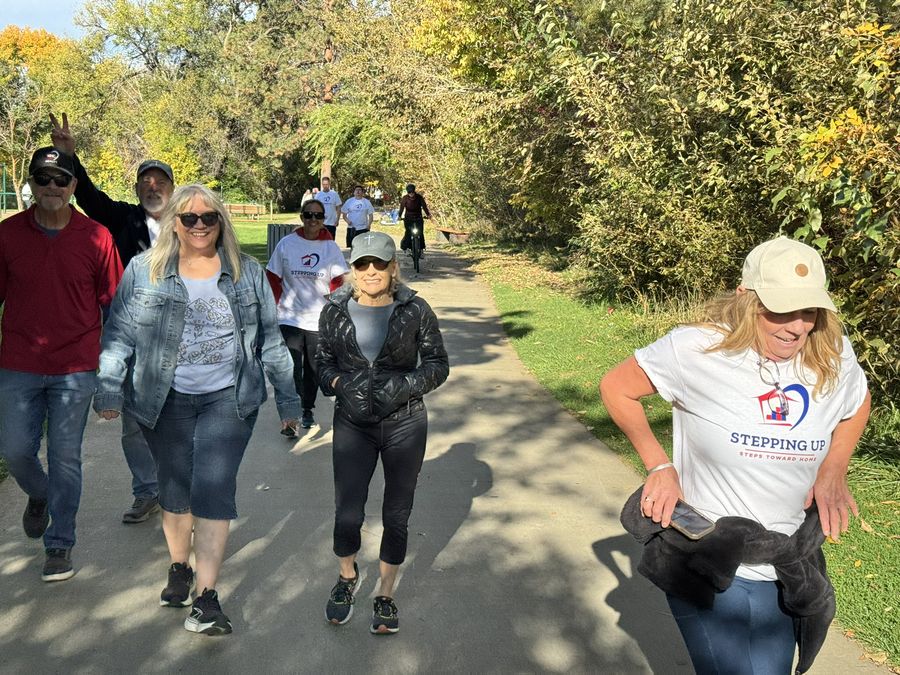 Smiling walkers on a tree-lined path in the sun