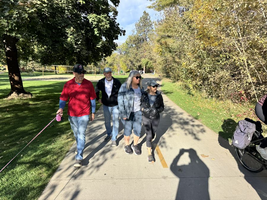 A group walking the park loop on a sunny morning