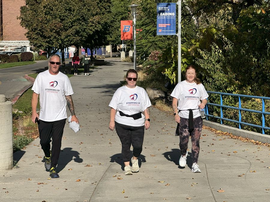 Three walkers in Stepping Up shirts on the riverside path
